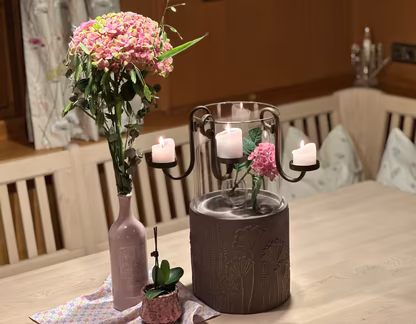 Blumenstrauß und Kerzen auf Holztisch