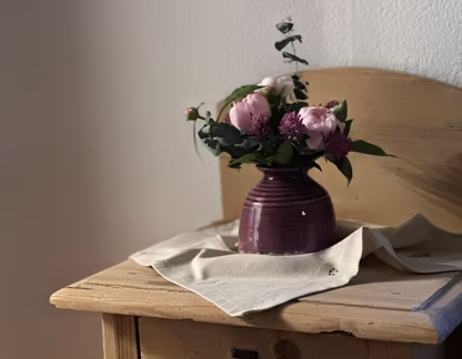 Blumenstrauß in Vase auf Holzkomode